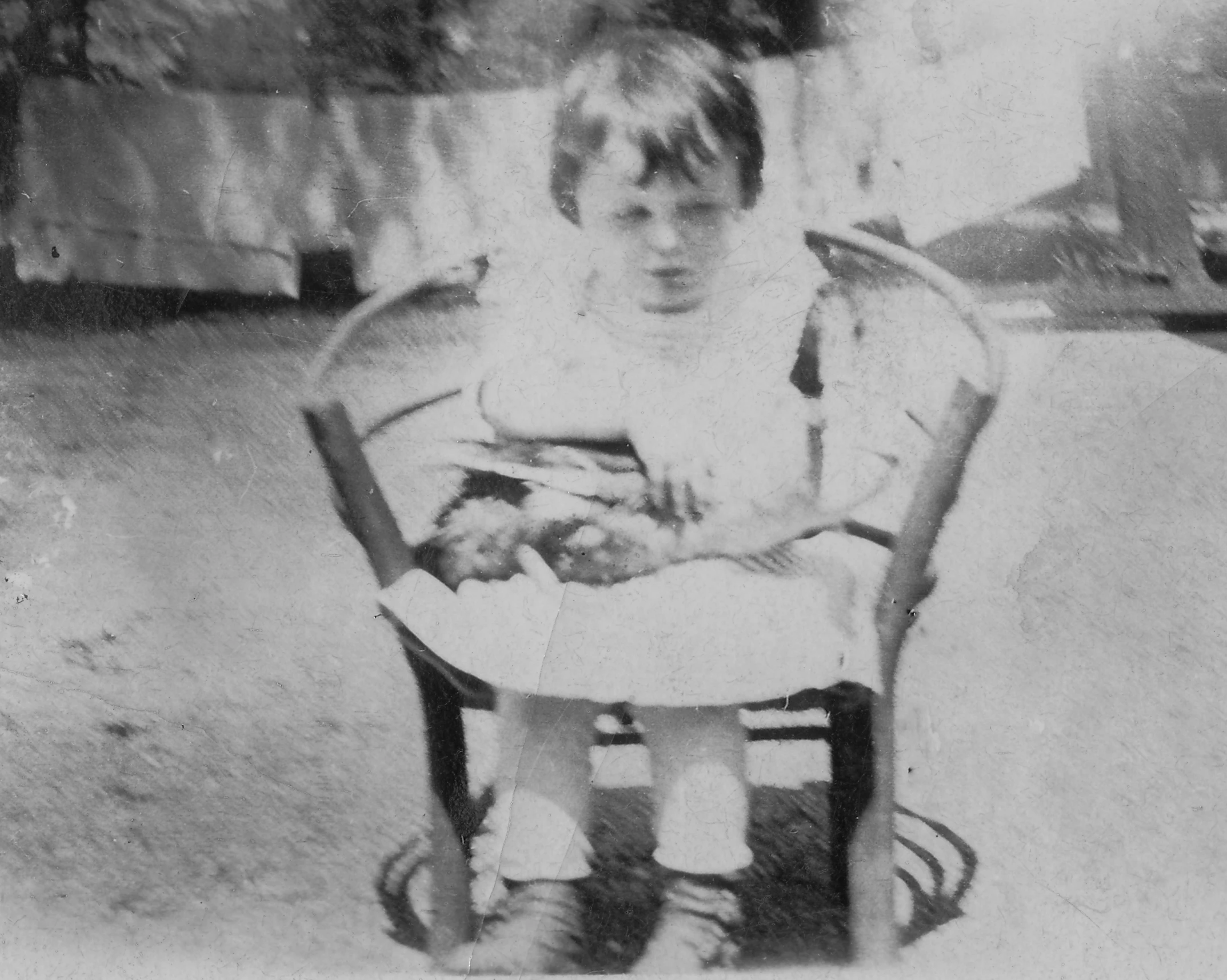 a boy sits in a chair holding a cat