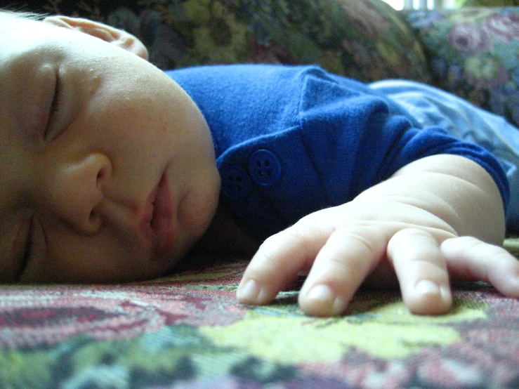 a baby is lying on a floral print blanket