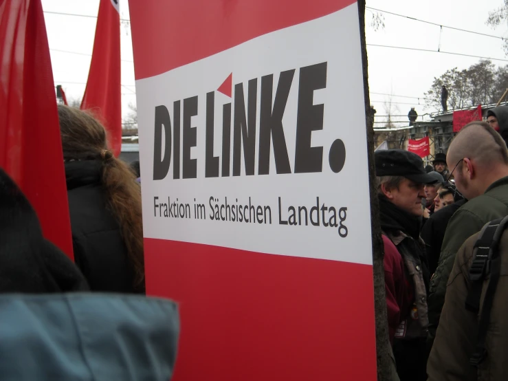 people walking in an outdoor demonstration area holding signs