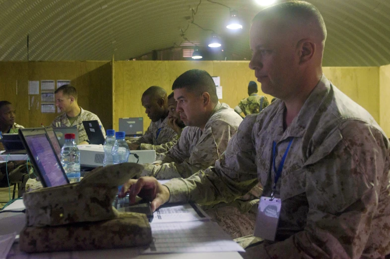 the military men are sitting in a group at a table