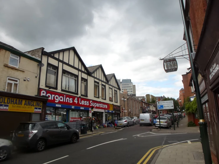 a city street has shops, businesses and vehicles on the sidewalks