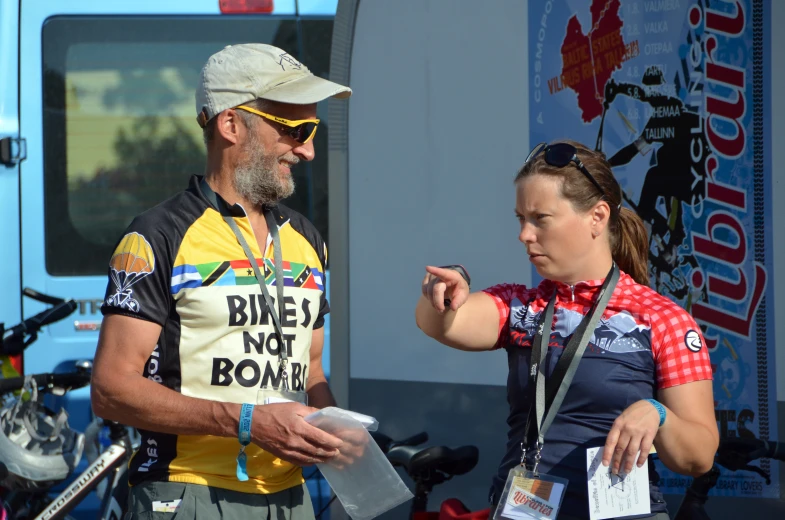 two women and a man are talking on a sunny day