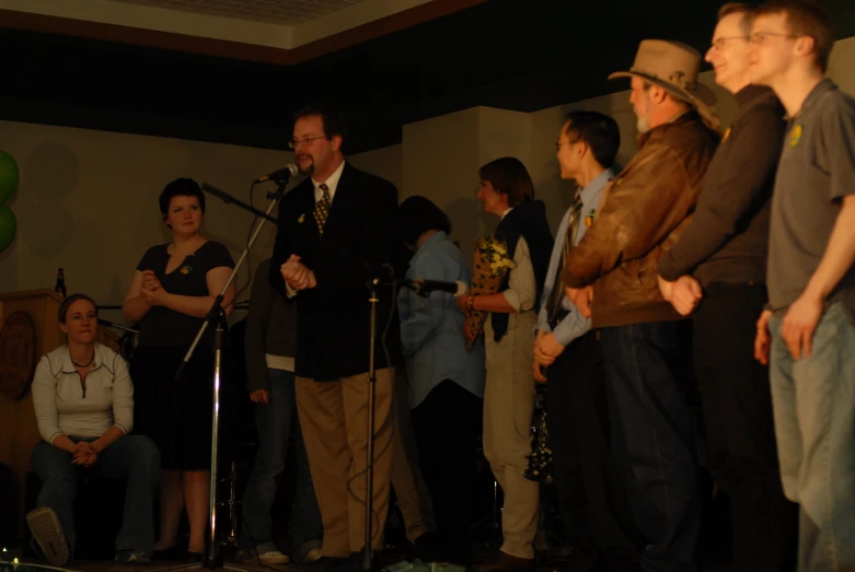 people watching a man singing into a microphone at a party