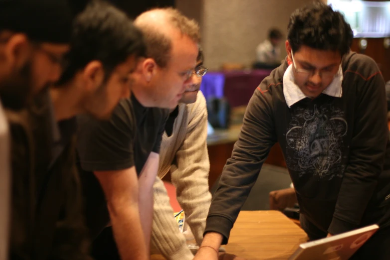 three men are looking at soing on a screen