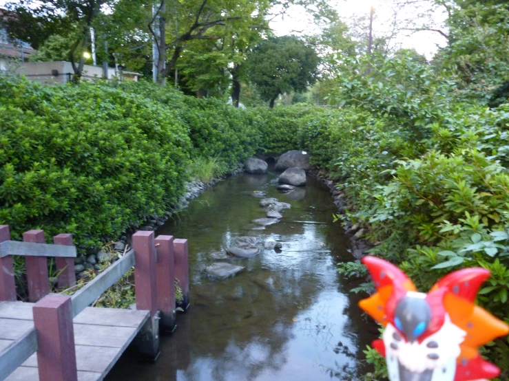 a statue in the shape of a bird stands next to a canal filled with water