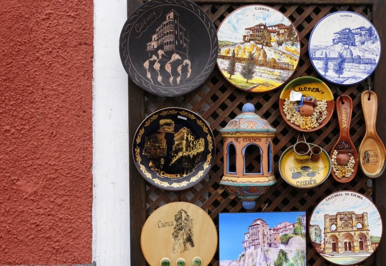 many plates on a wooden rack outside a building