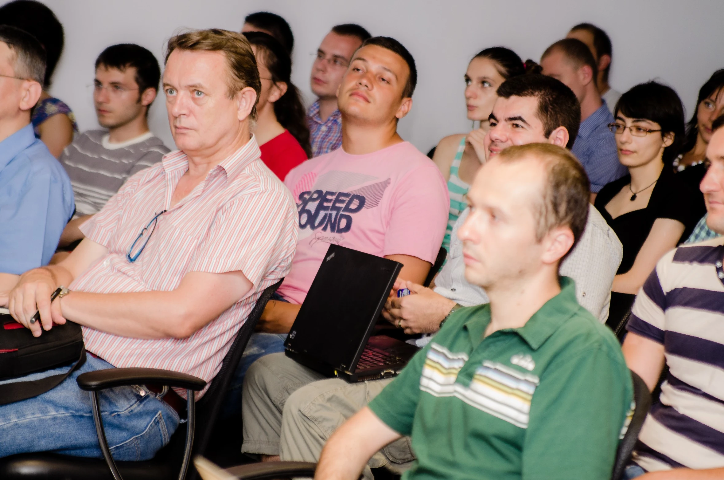 group of people seated in rows watching soing