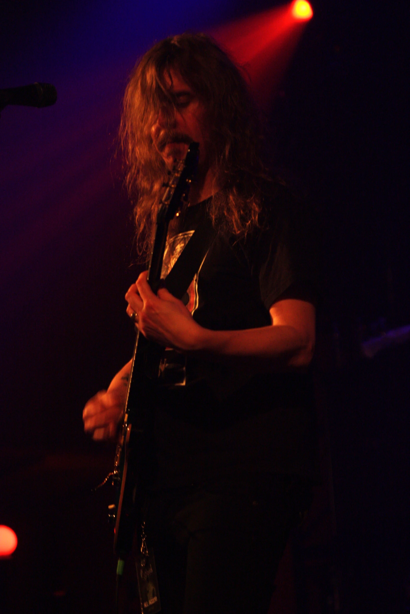 a male concert performer on stage at a dark venue