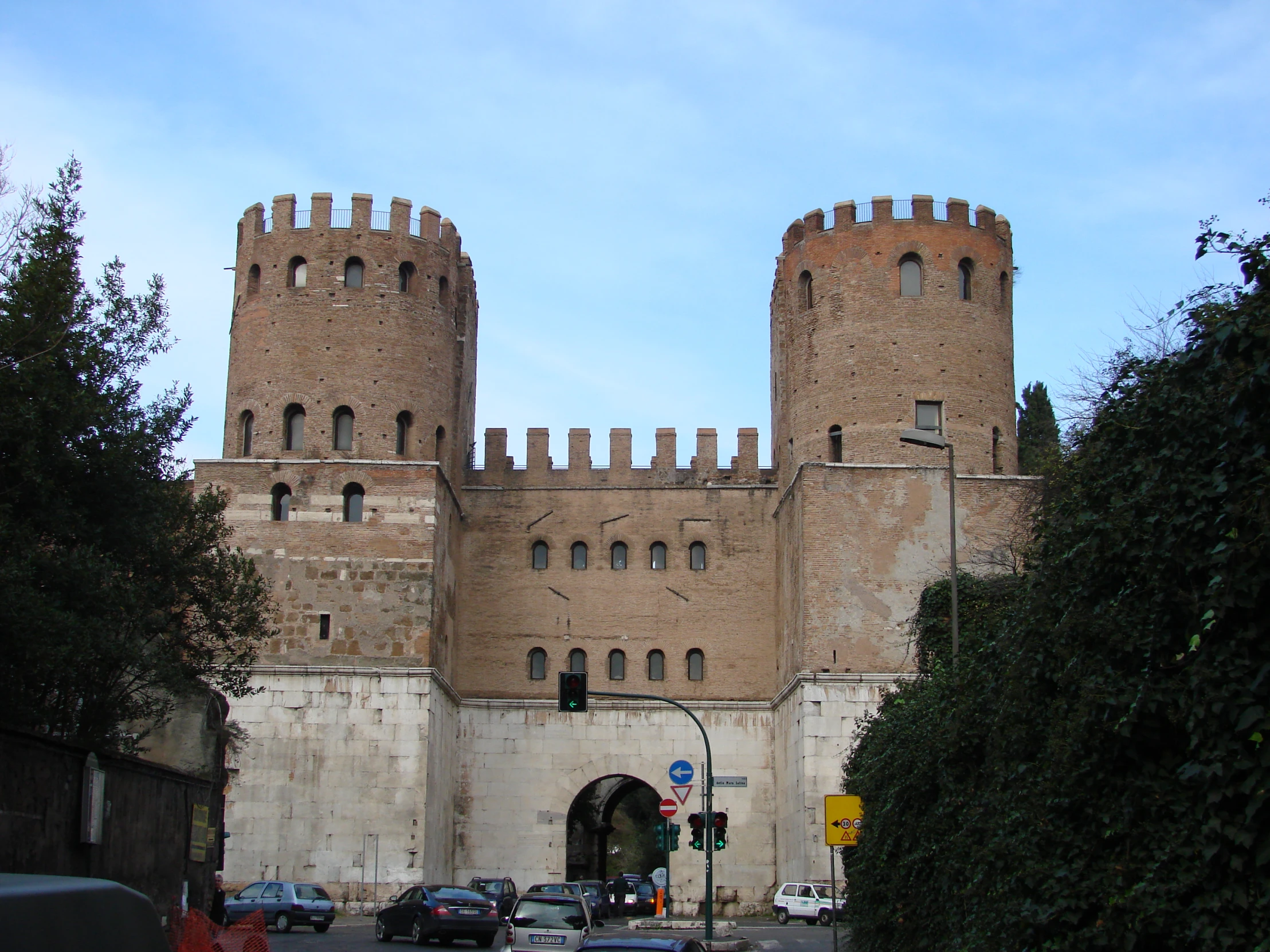 a very tall brown brick castle sitting on top of a road