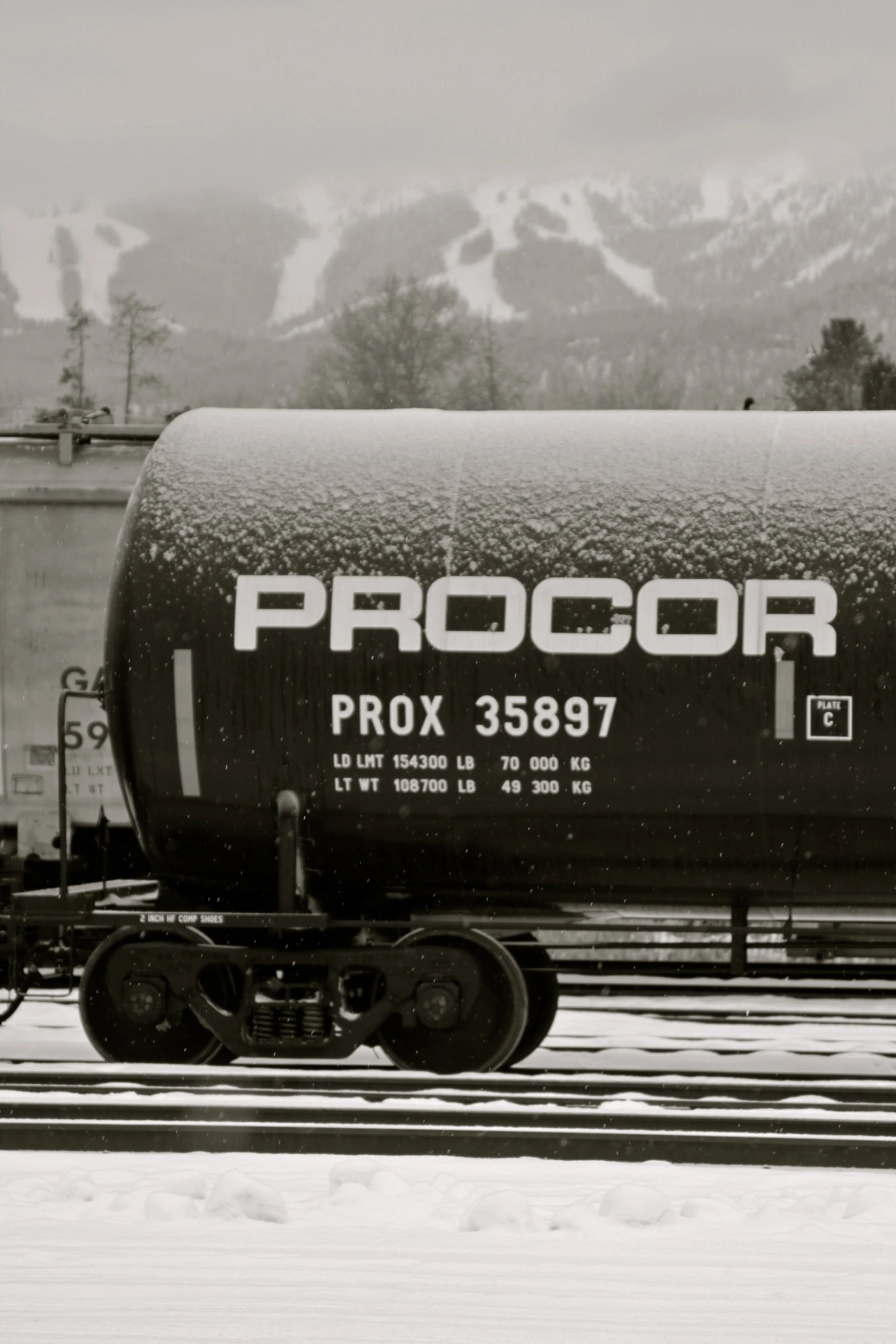 a train car with a tanker in a snowy landscape