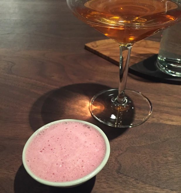 two drinks and a drink glass on a wooden table