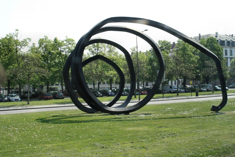 a metal sculpture sits in a grassy park