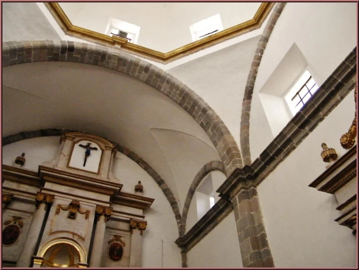 a church wall with stone columns and a clock