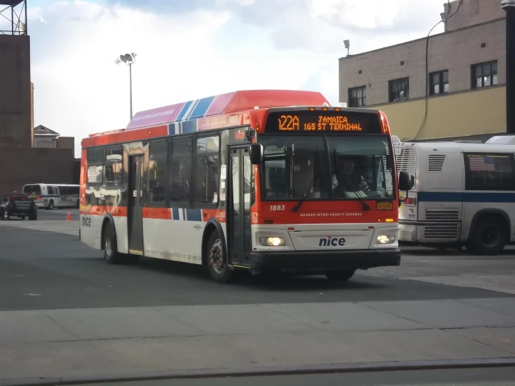 a large red and white city bus at a stop