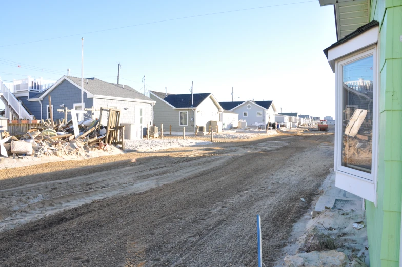 a road surrounded by dirt and some houses