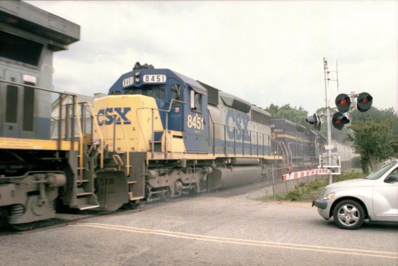 a train that is going down the tracks next to a car