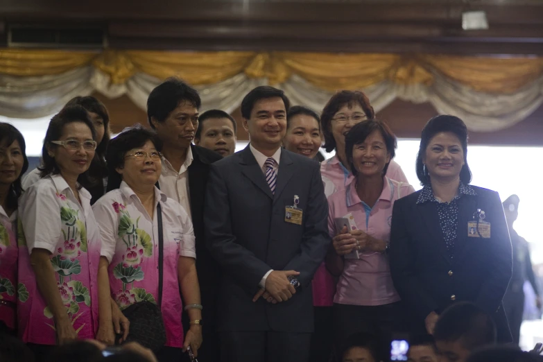 a group of people in suits and ties are posing for a picture