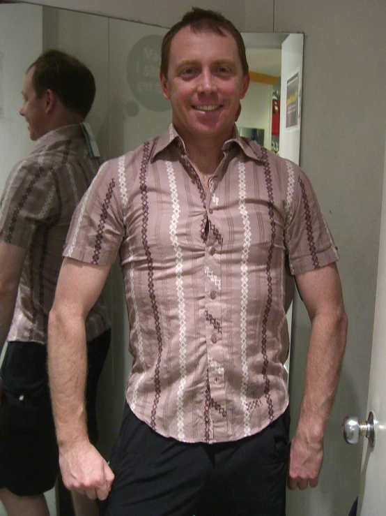 a man smiling for the camera with his hand in his pockets