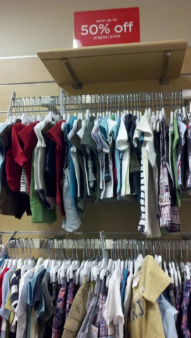 there are dozens of shirts hanging on the rack