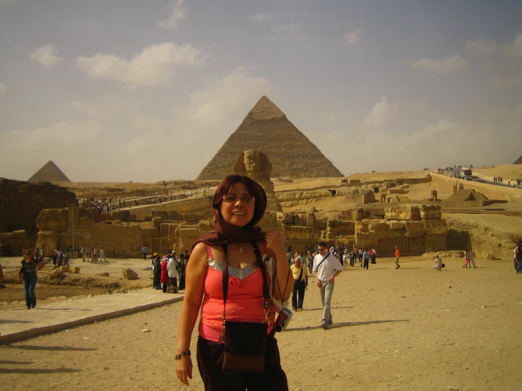 a woman poses for the camera in front of the great pyramids