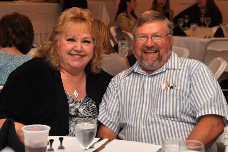 a man and woman sitting at a table with drinks