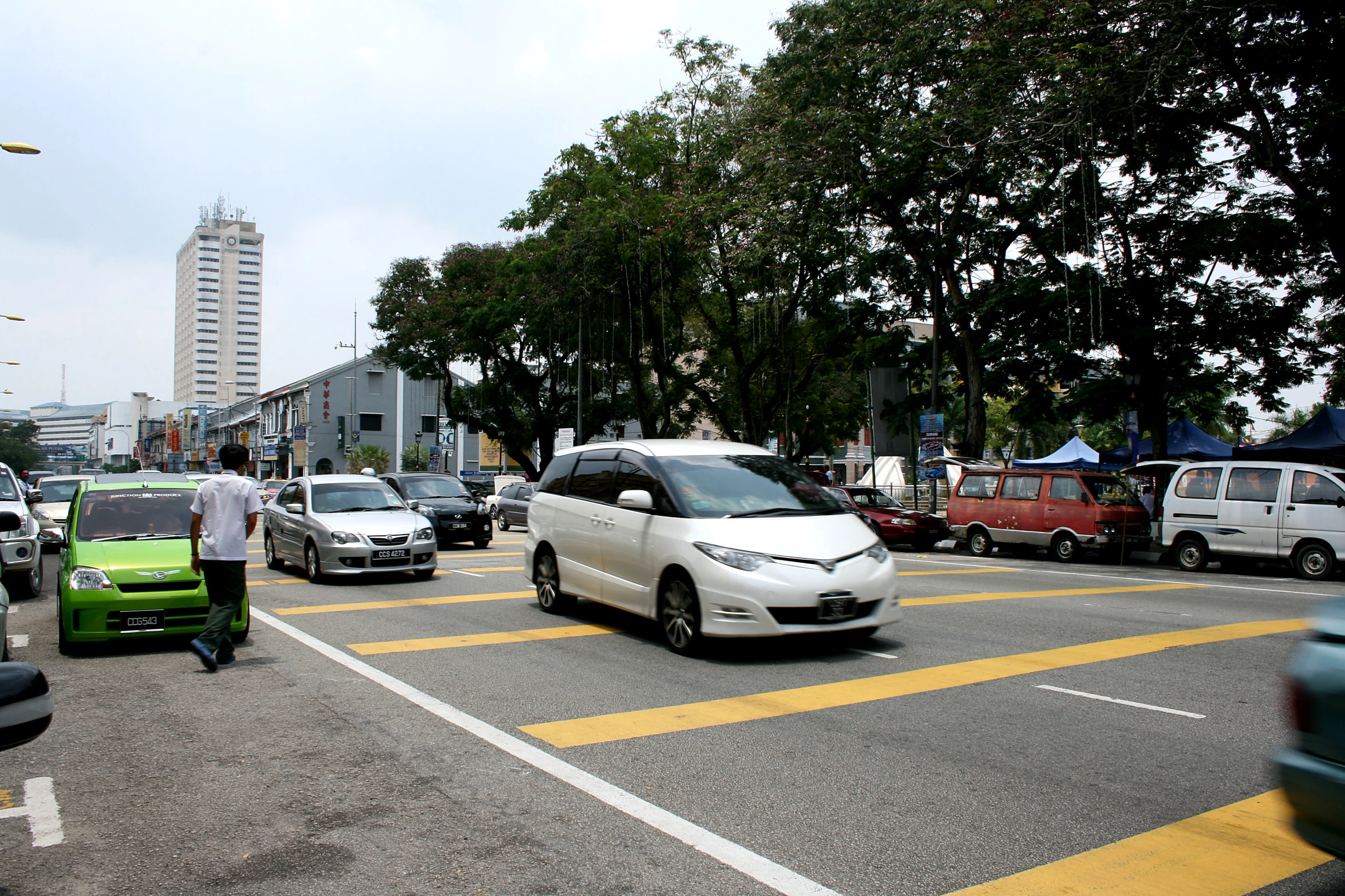 cars on the road near buildings and people