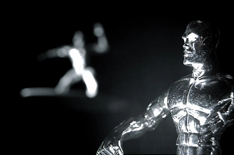 two plastic figures on a table in the dark