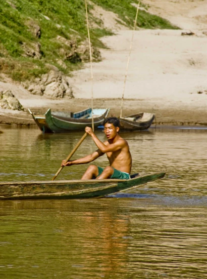 a  rowing a canoe in the middle of a river