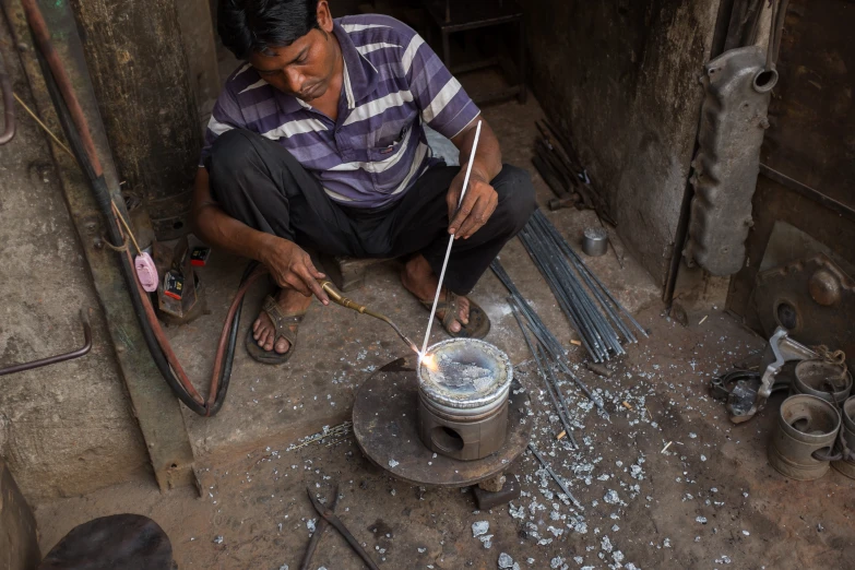 a man uses chopsticks to make soing from the ground