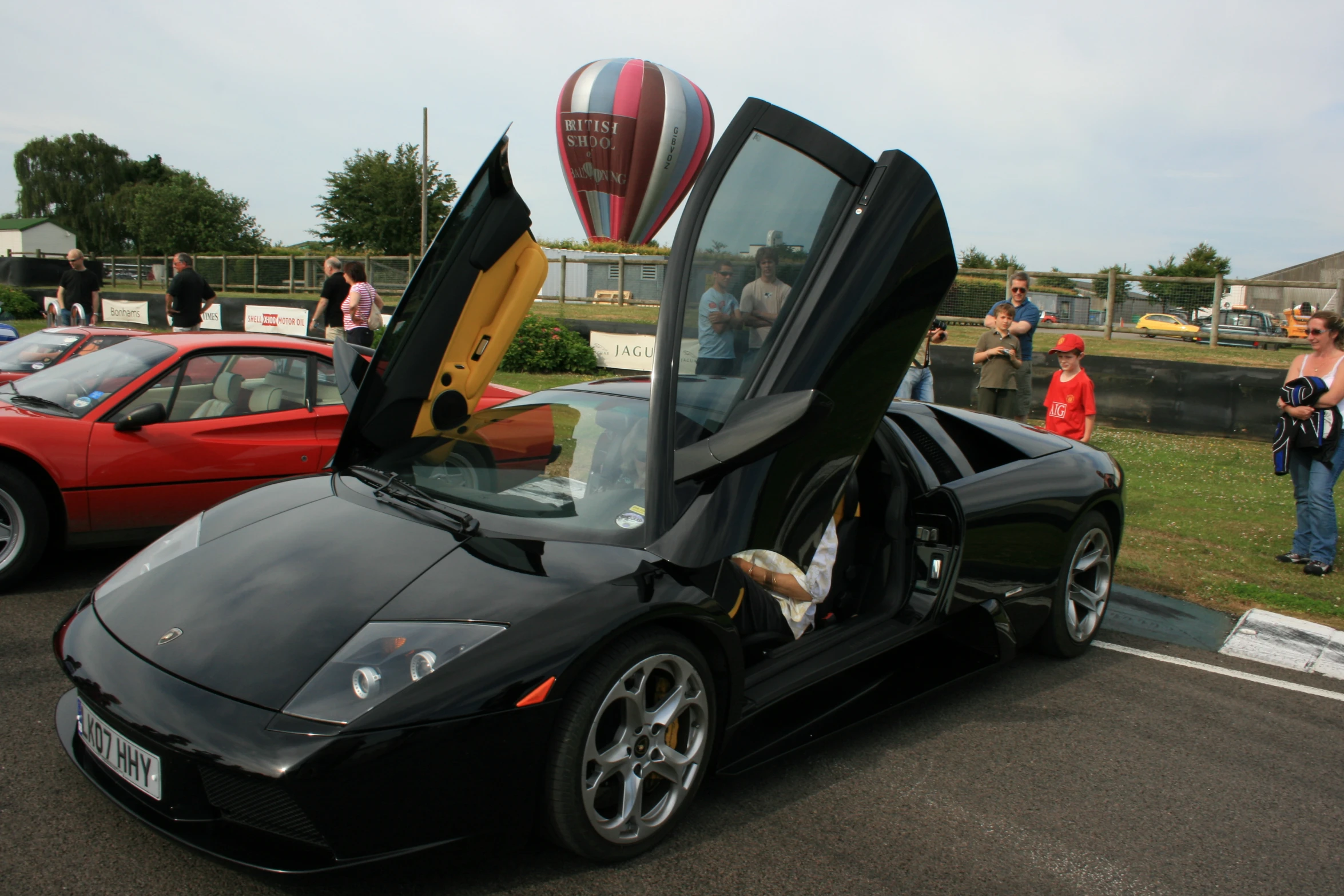 a black car with an open door on a parking lot