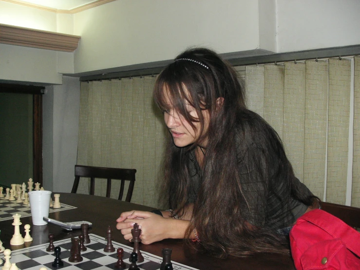  playing chess against each other at a chess board table