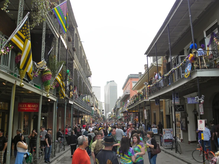 people walk down a street in front of several stores