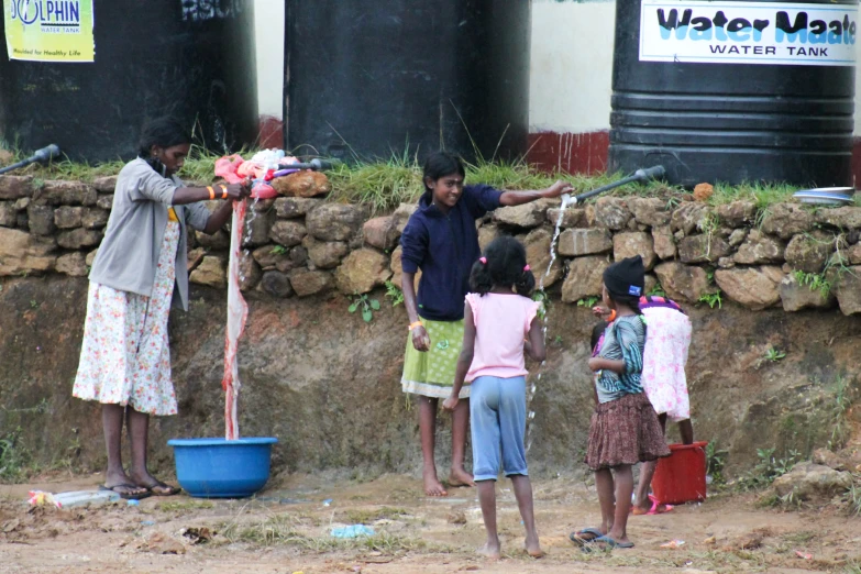 an indian family is outside watering the water