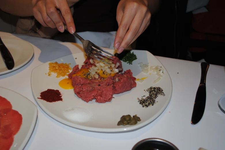 person  up a meatball on a white plate