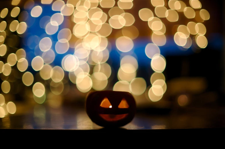 a pumpkin sits next to boket lights