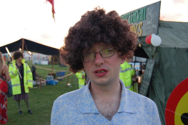 a man with curly hair is looking towards the camera