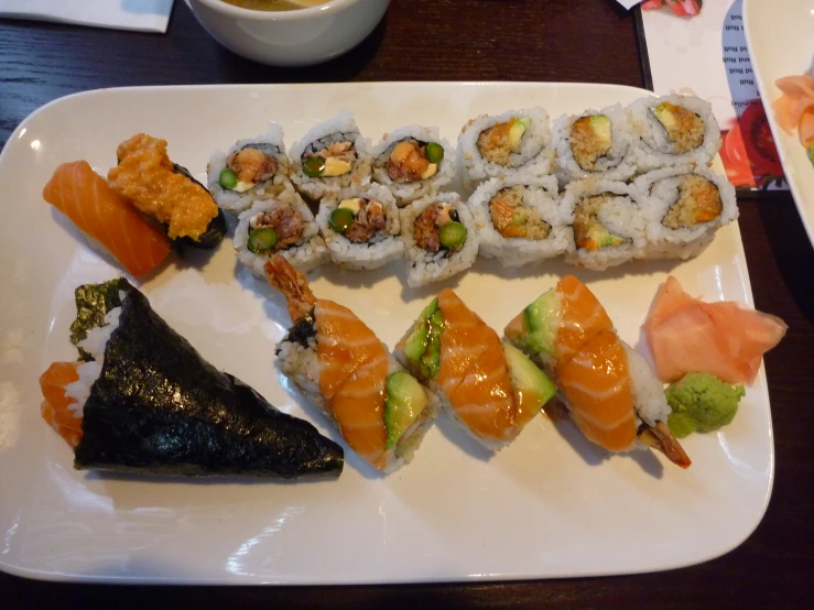 a plate of sushi with chop sticks