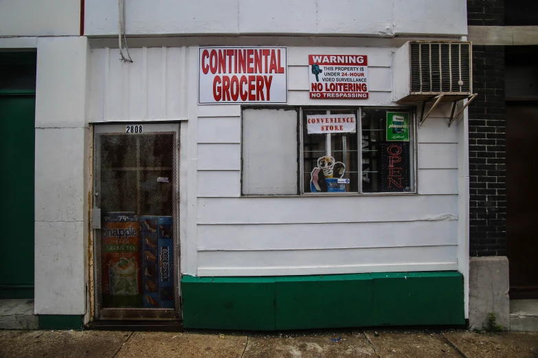 a picture of a white building with many signs and advertits