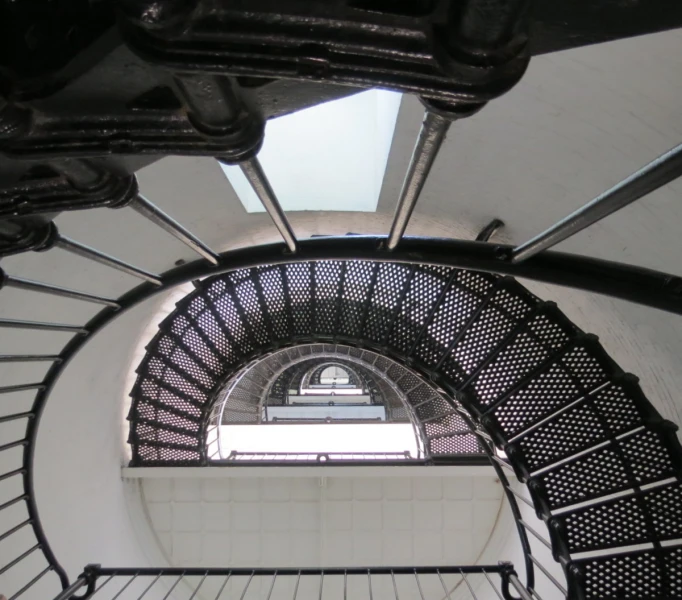 a black and white image looking up at the top of a metal stair lift