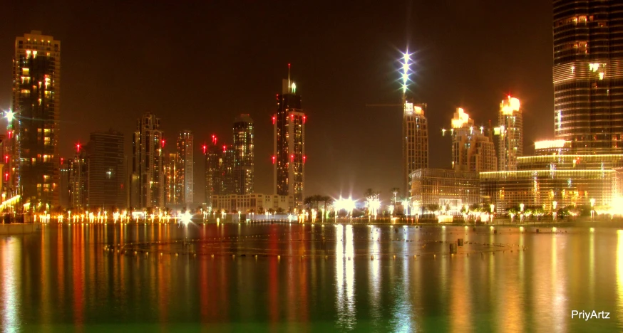 city skylines lit up at night with lights reflecting in the water