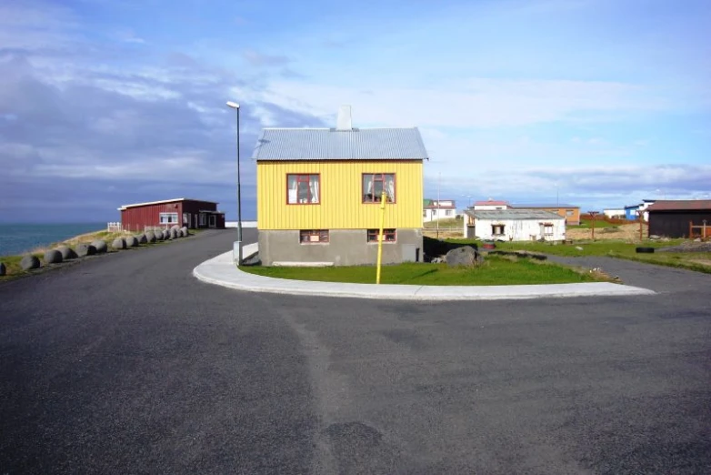 yellow house on the side of an empty street