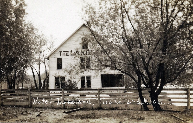 an old black and white po of a house that has trees around it