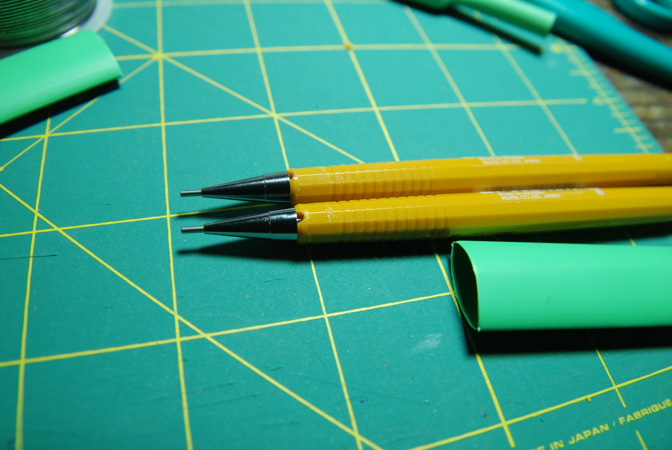 some markers are next to two pens on a  board