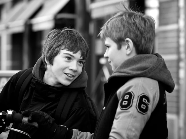 two young men are talking on the street