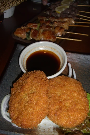 fish sticks with dipping sauce in a bowl next to plates of food