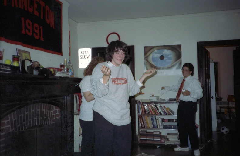 two women stand in a living room holding onto some food