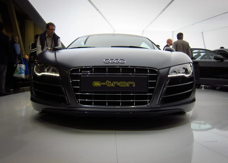 several people viewing an audi car in the showroom