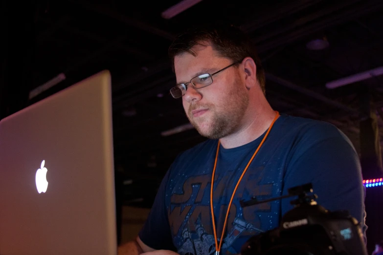 a man is looking at an apple laptop