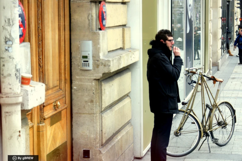 a man standing in front of a building talking on his cell phone