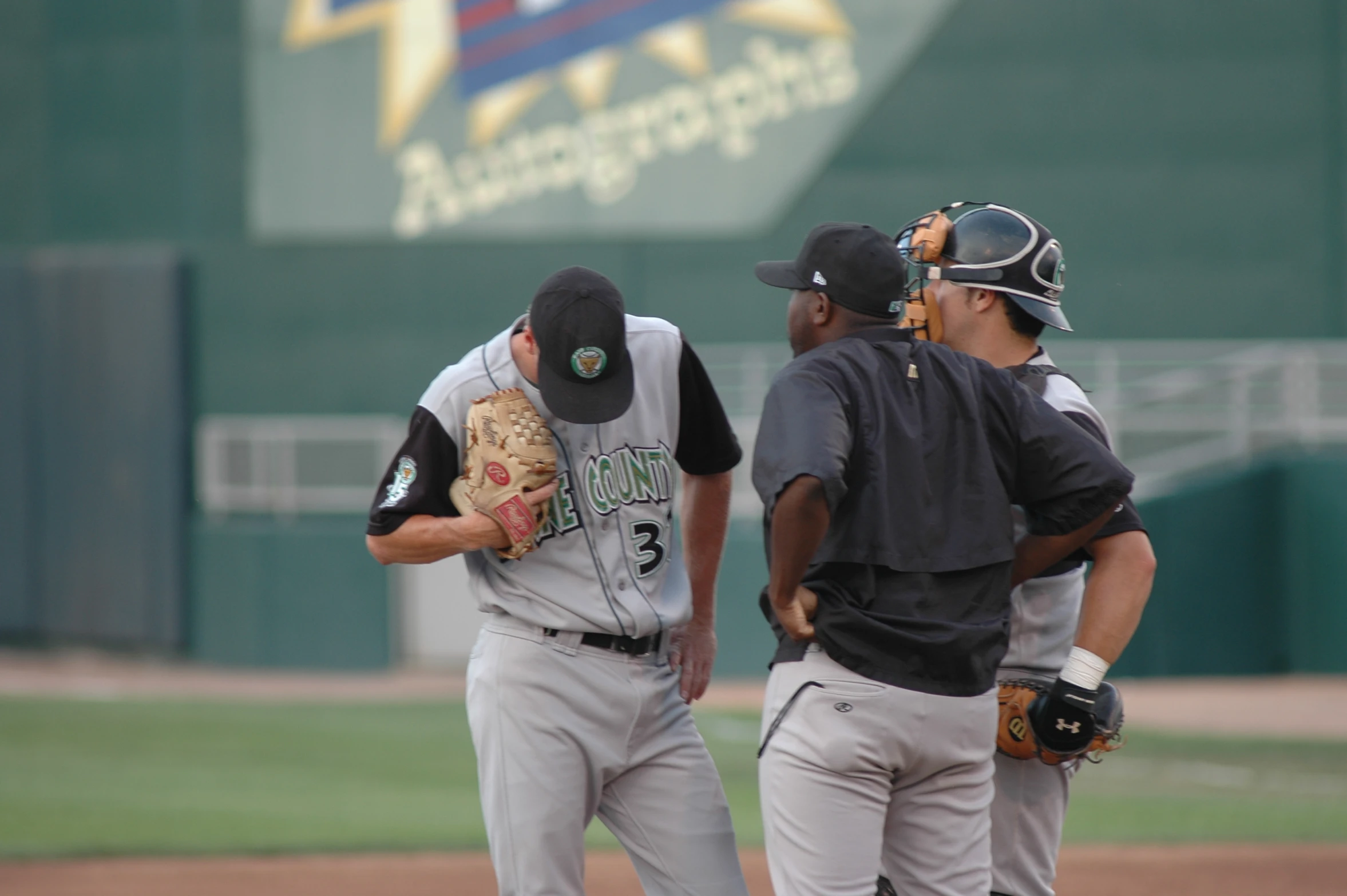 three men in baseball uniforms standing on a field